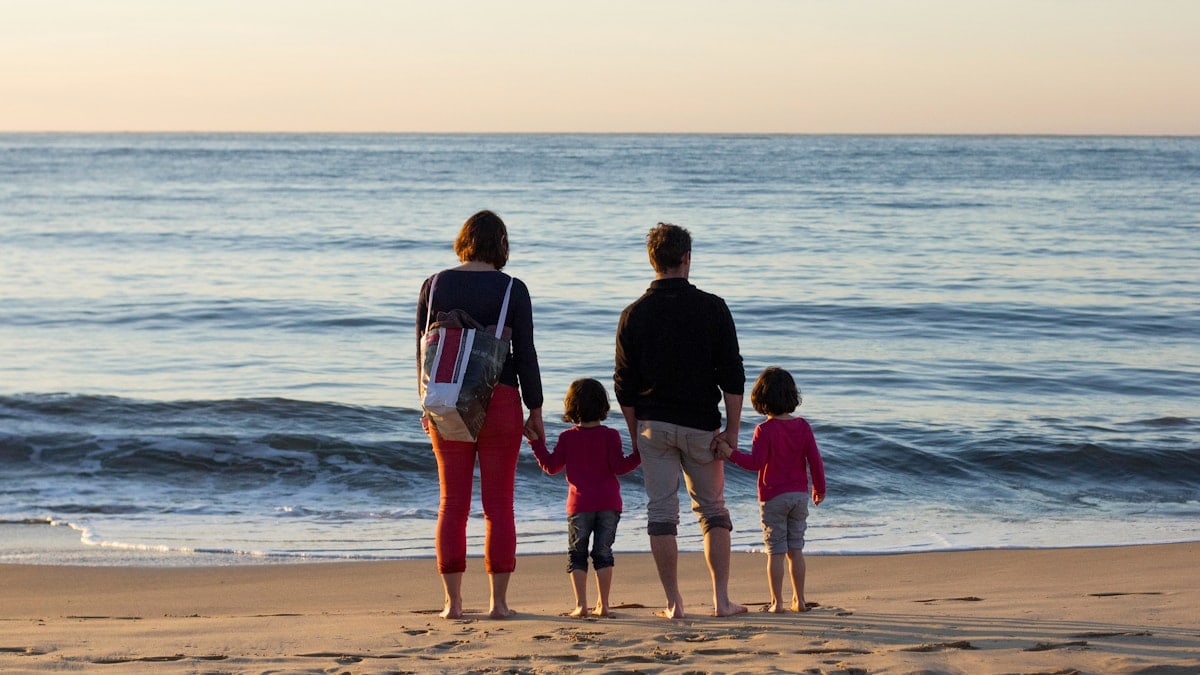 family of four standing at the seashore
